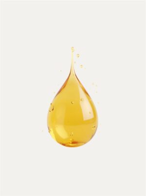 A single, translucent golden oil drop suspended against a plain light background.