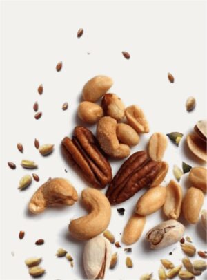 A variety of raw nuts and seeds including cashews, pecans, and pistachios scattered on a white background.